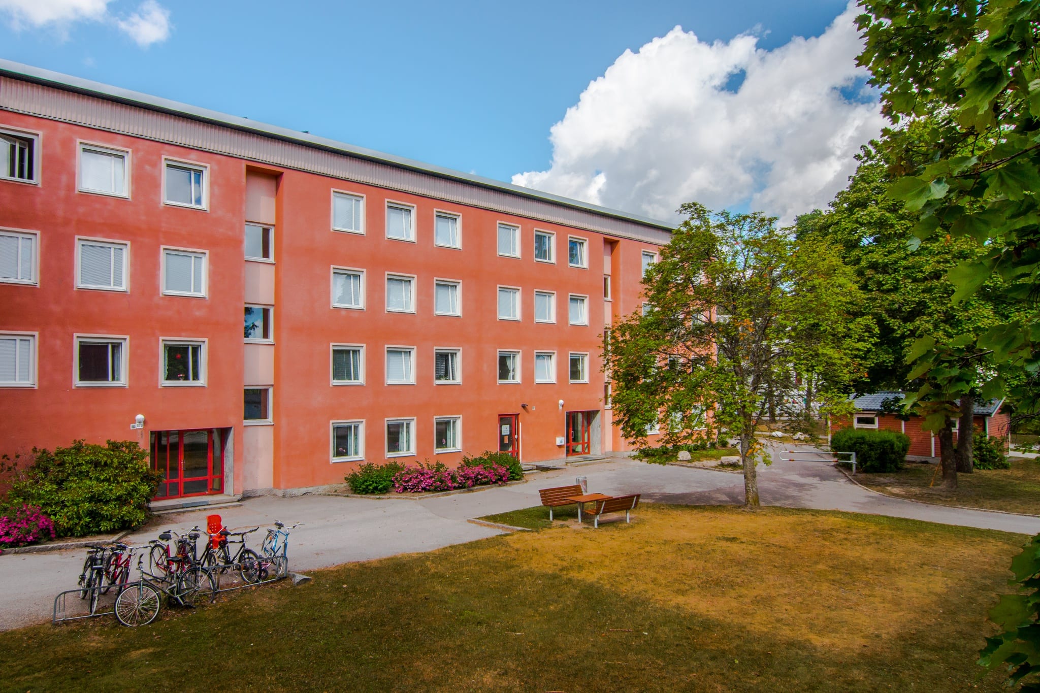 Fasaden på huset på Pettersbergsgatan 47B med gräsmatta och gröna buskar utanför