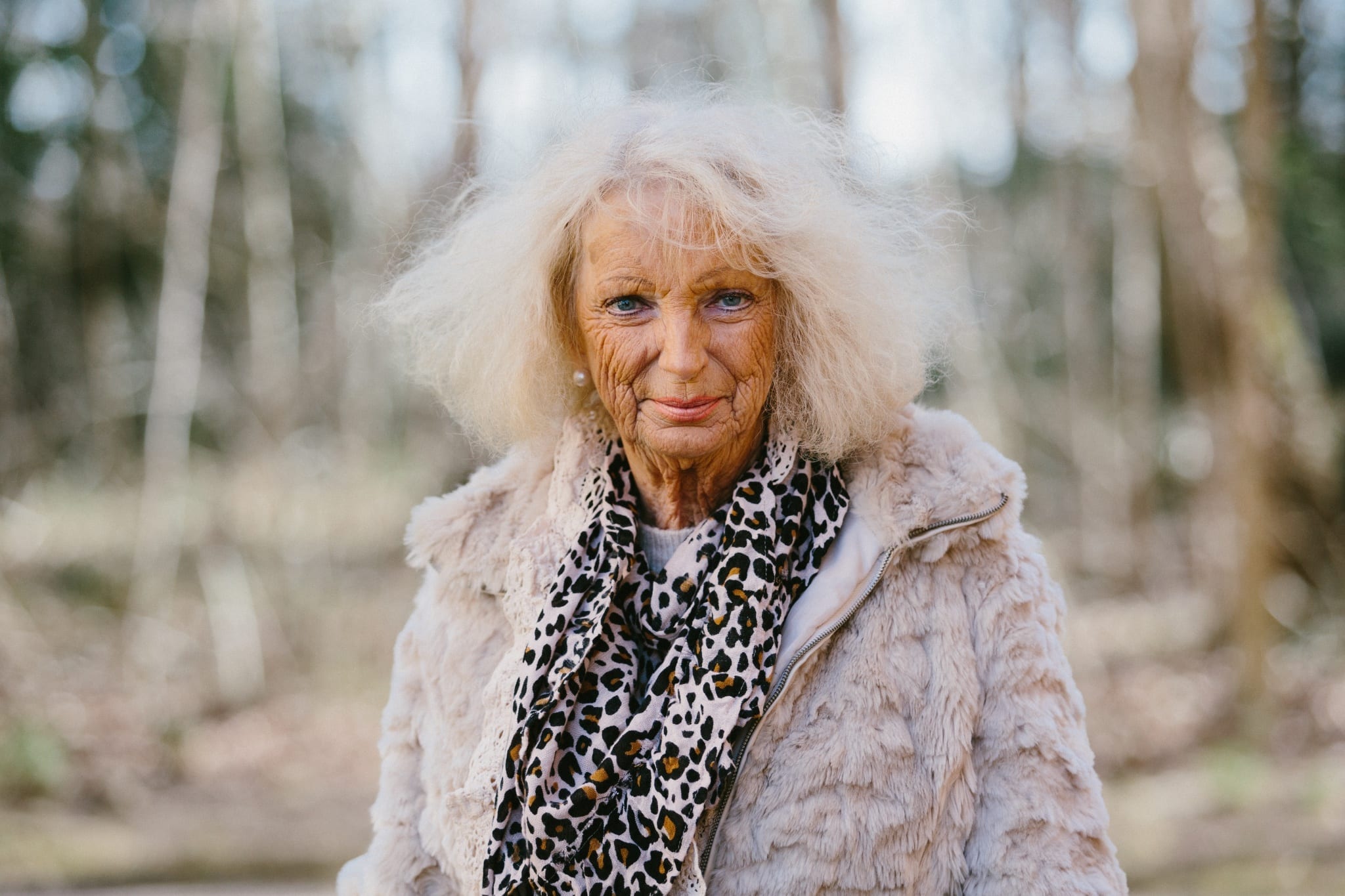 Porträttbild på Irene, en äldre kvinna iklädd fuskpälsjacka och leopardscarf.