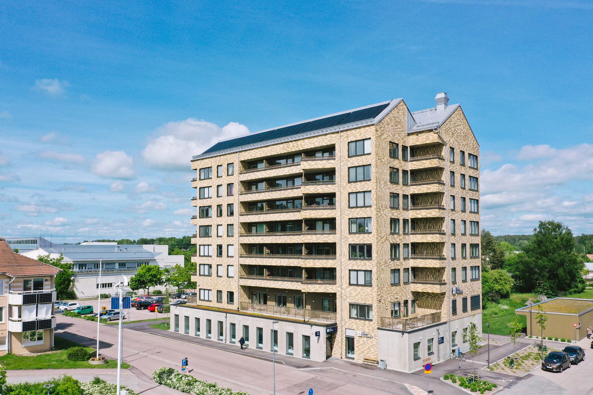 Flerfamiljshus i 8 våningar med solceller på taket och vårdcentral på entréplan.