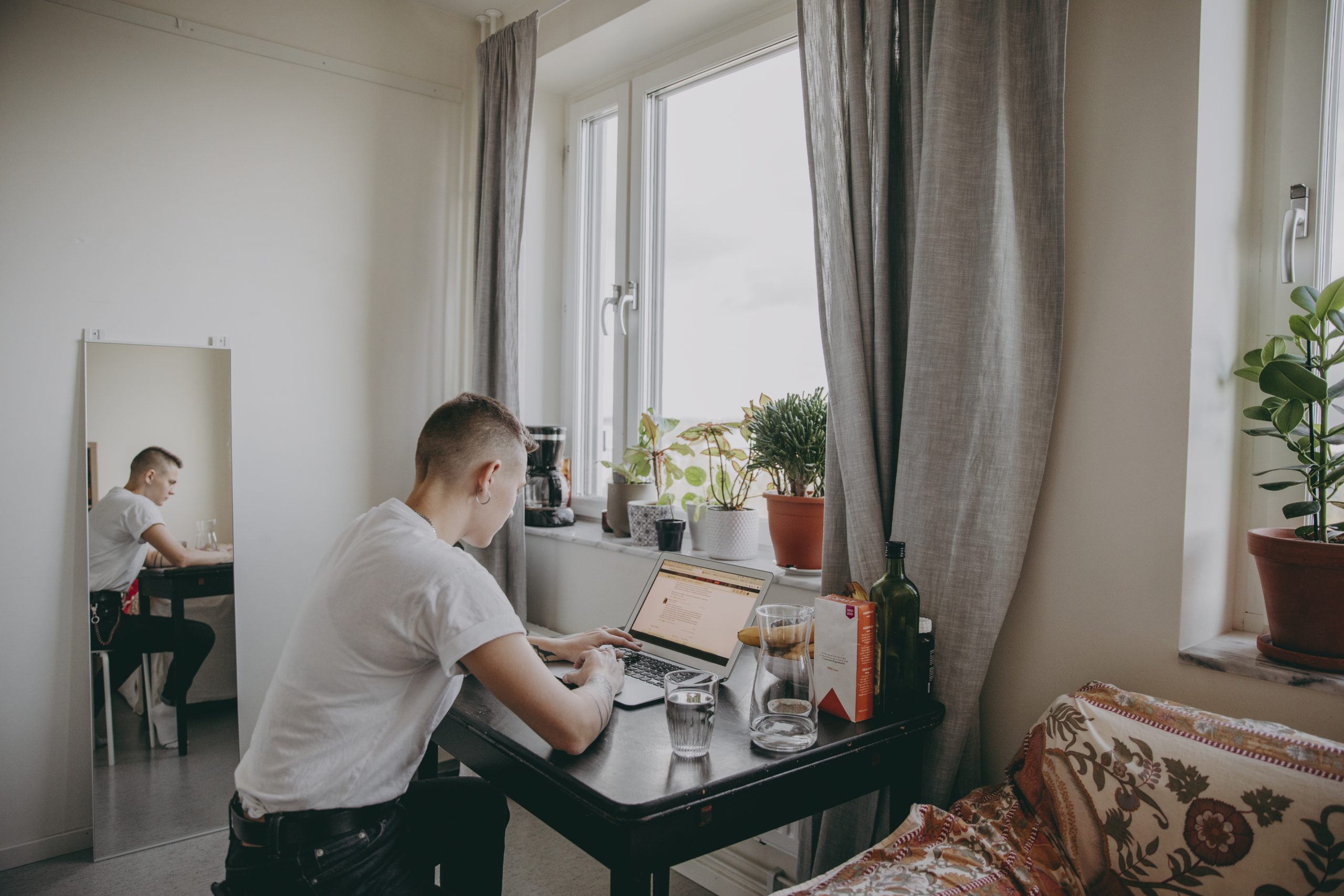 Ung person i första lägenheten, Pluggar vid sin laptop