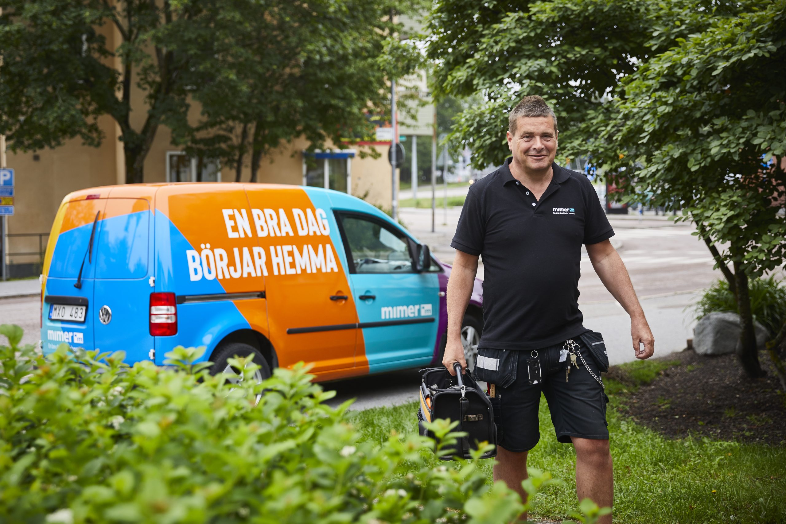 Kvartersvärd går från sin bil med verktygslåda