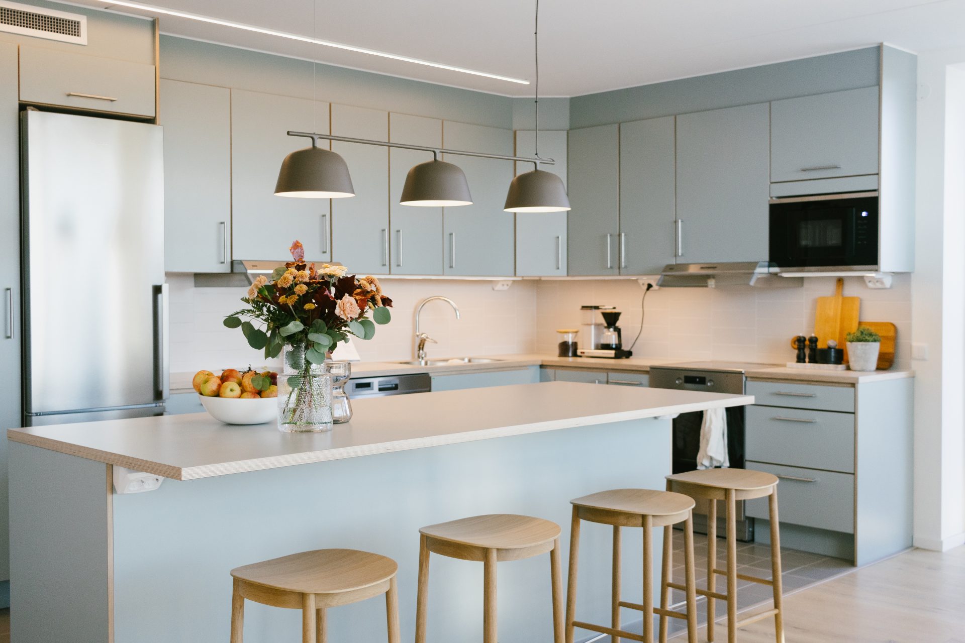 Kök med gröna luckor och köksö.