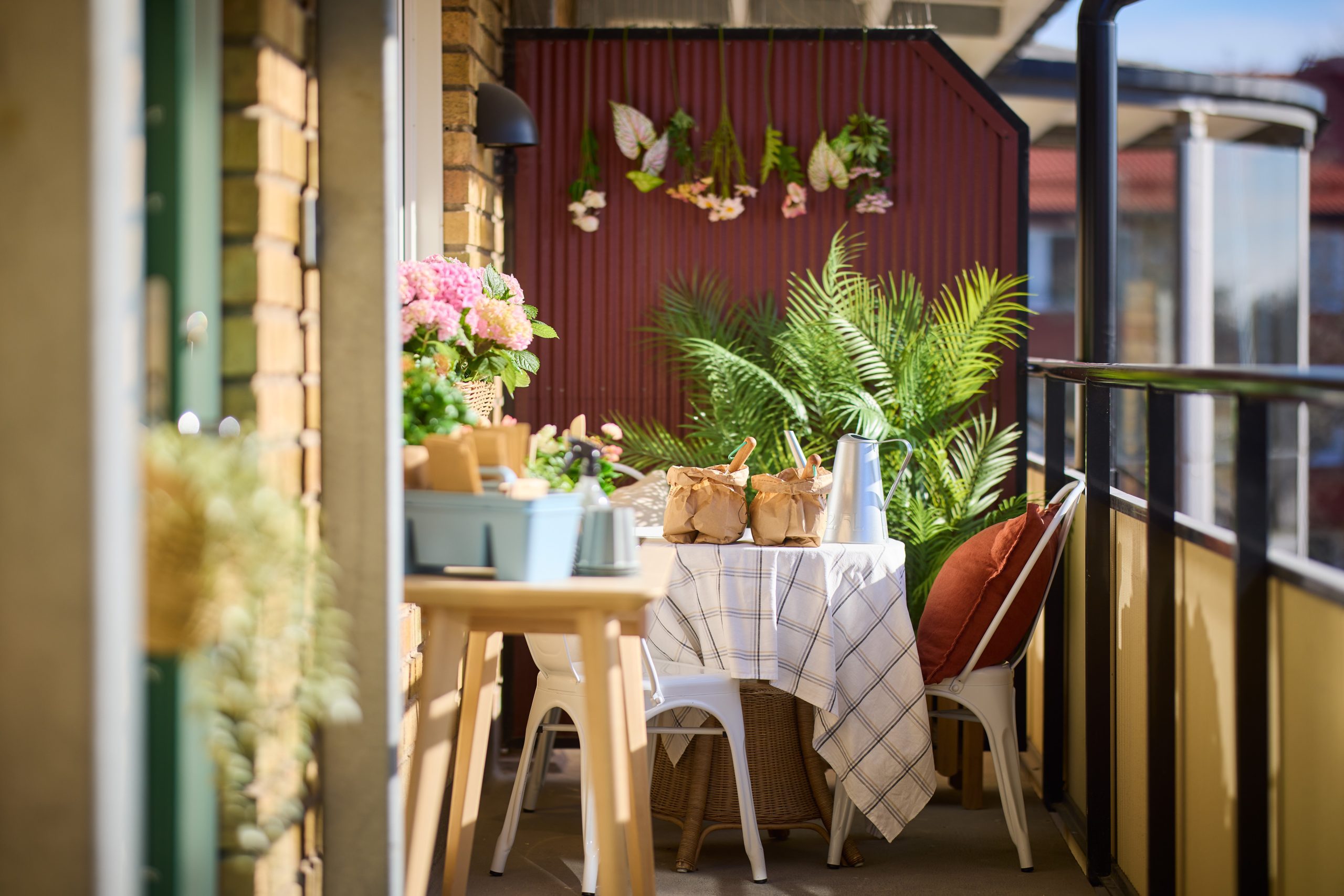 loftgång med utemöbler och blommor